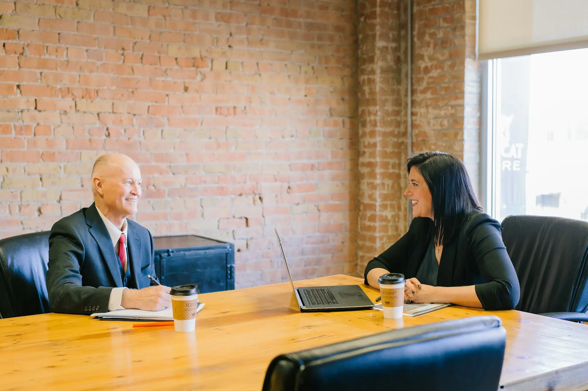 Businesswoman and man in conversation during a finance meeting inside a bright office