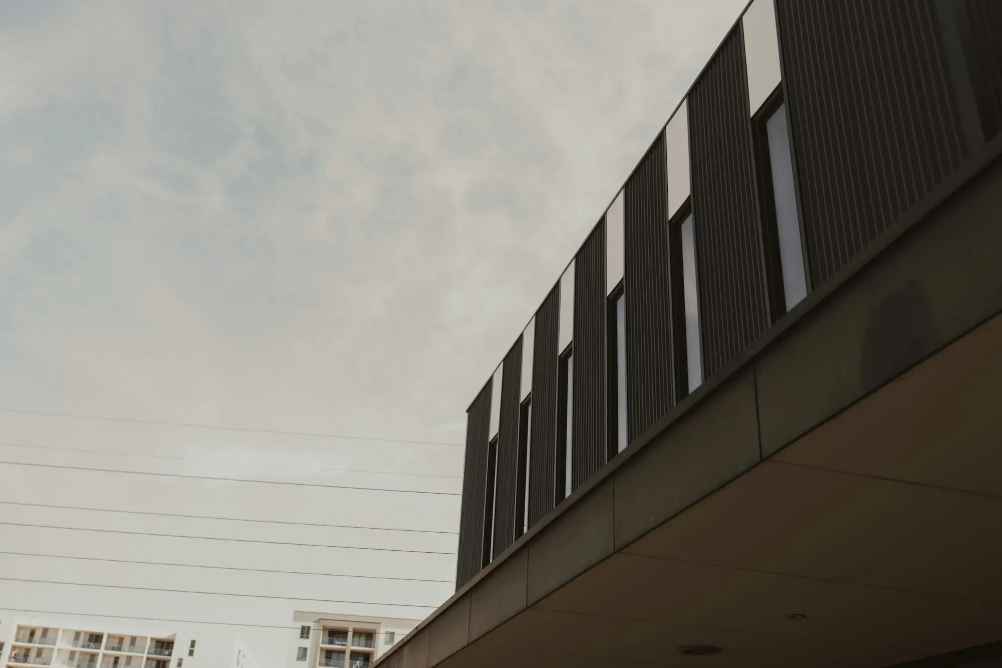 Sleek modern commercial office building with a dark facade and tall vertical windows in Perth
