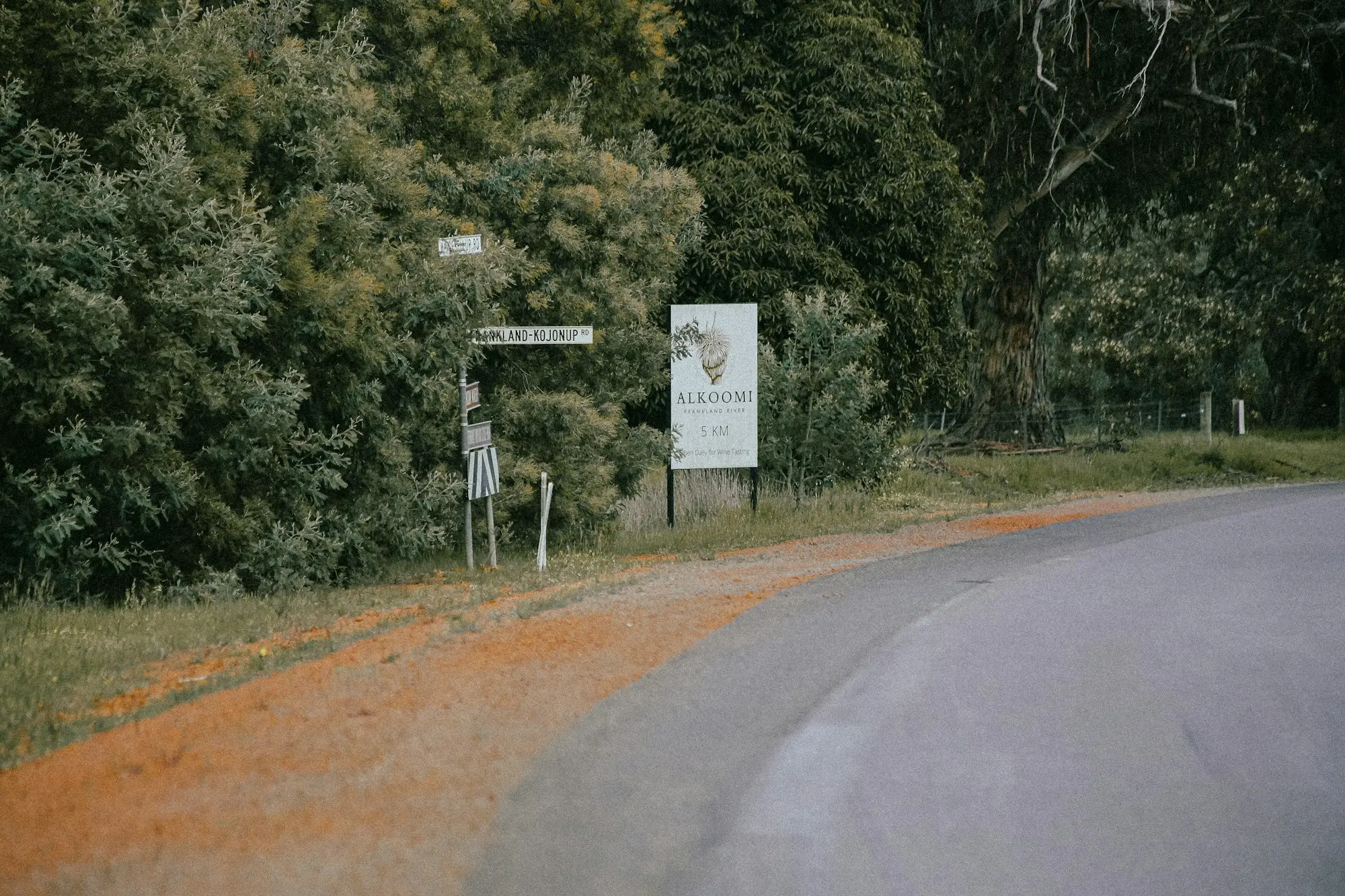 Curving country road with a roadside warning sign near Frankland River, Western Australia