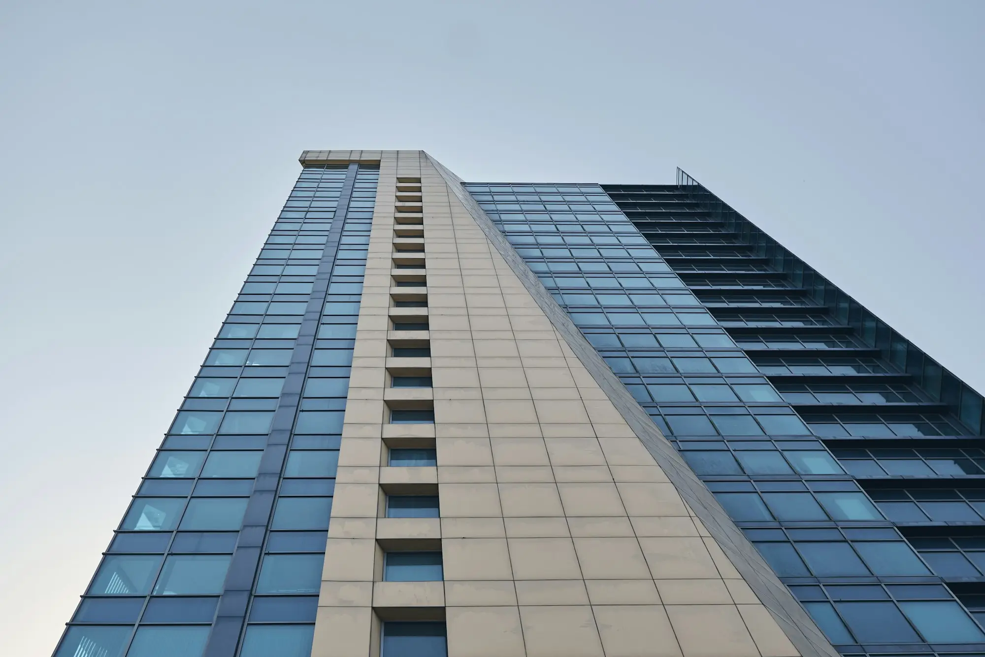 Residential apartment tower seen from street level against a clear sky