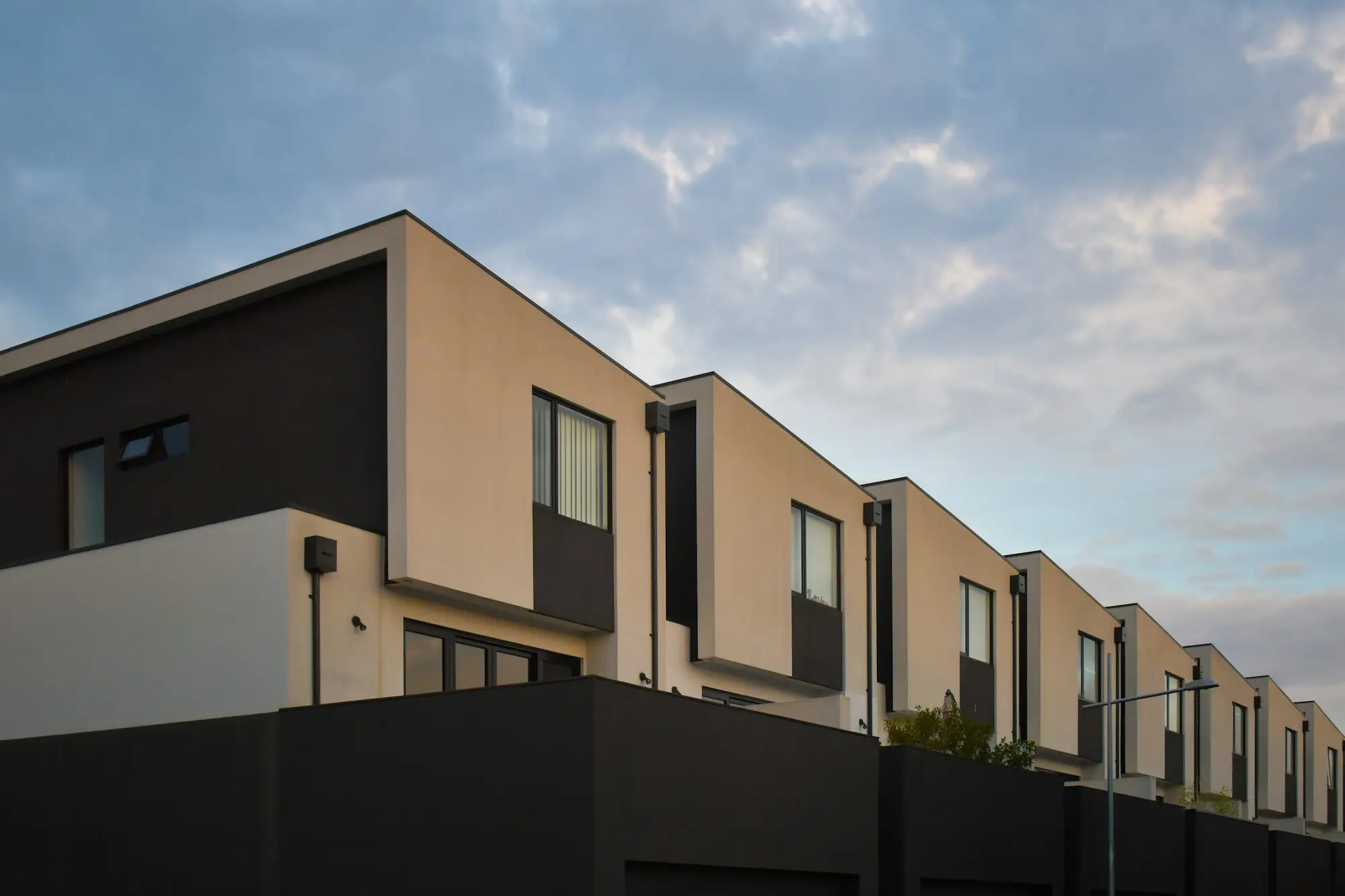 Modern residential apartment block with balconies under a blue sky in Melbourne