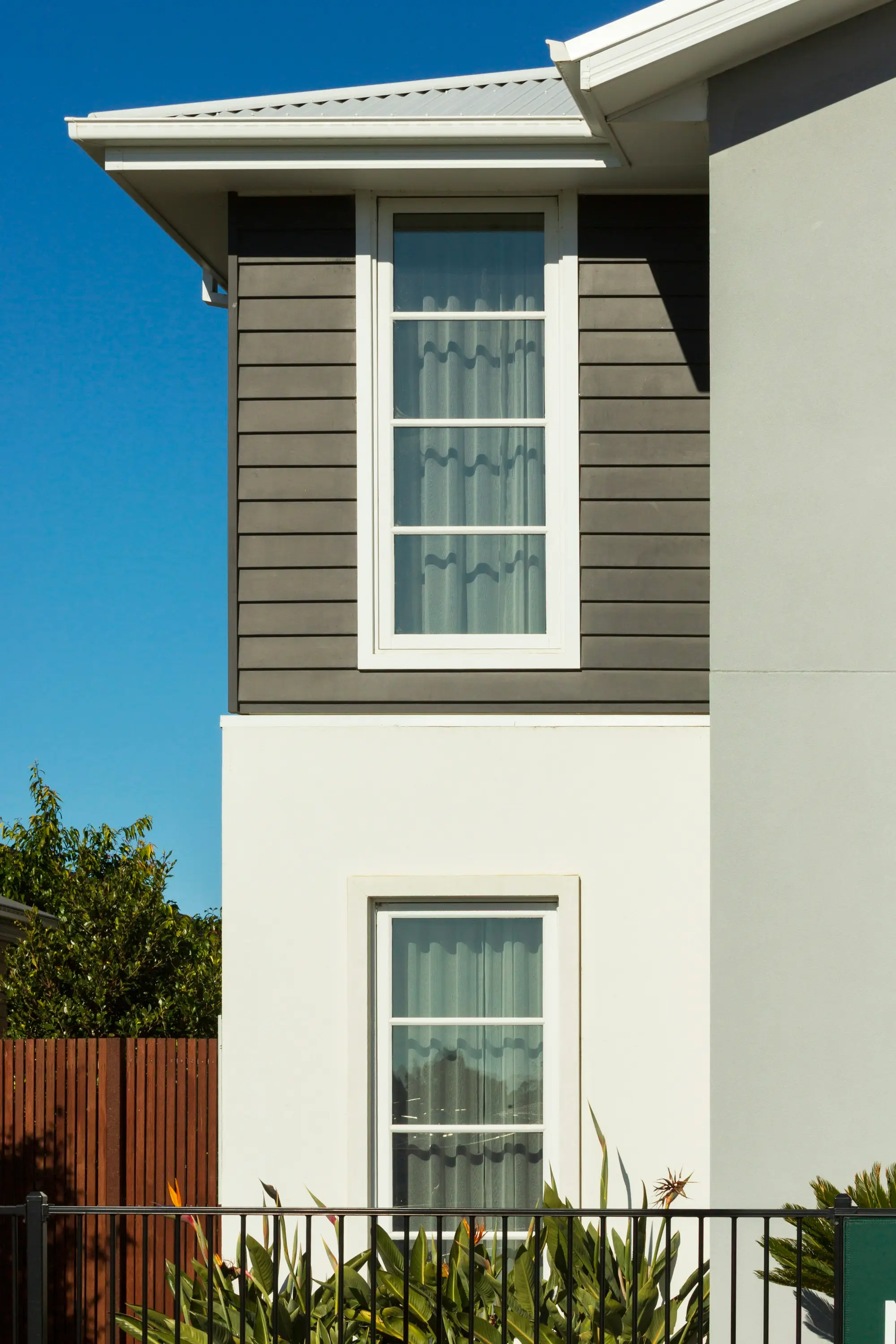 Modern Australian home exterior with tall windows and grey cladding, Melbourne