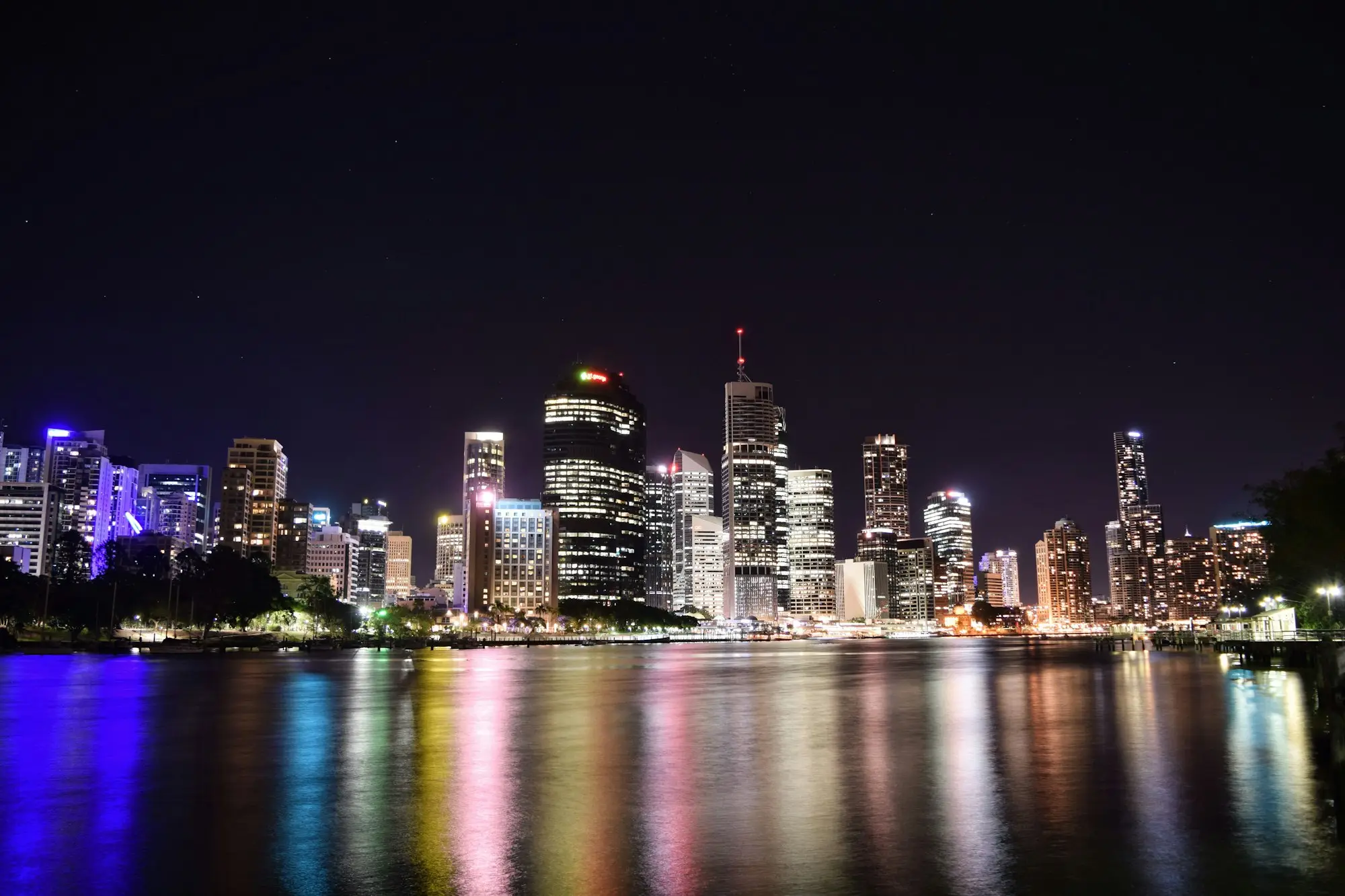 Brisbane CBD office towers lit up at night, reflected in the Brisbane River
